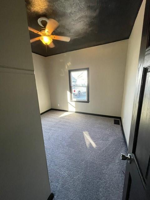 unfurnished room featuring ceiling fan and light carpet