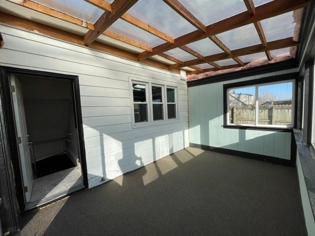 unfurnished sunroom featuring beamed ceiling and coffered ceiling