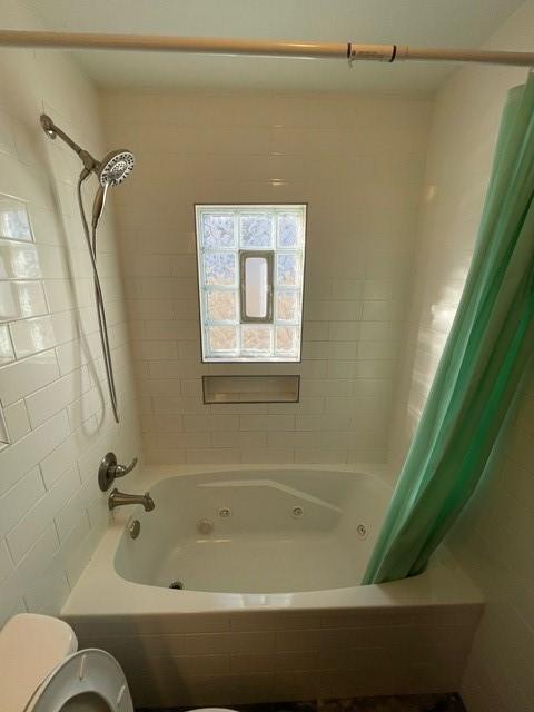 bathroom with toilet and shower / bathtub combination with curtain