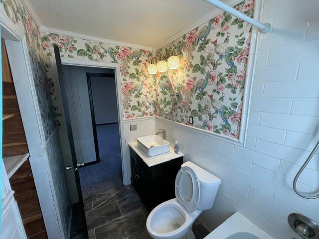 full bathroom with crown molding, bathing tub / shower combination, vanity, and toilet