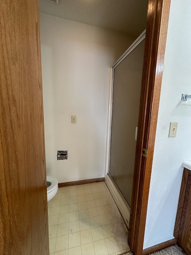 bathroom with vanity, a shower with shower door, and toilet