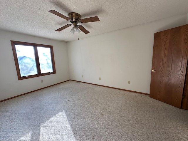 carpeted empty room with a textured ceiling and ceiling fan