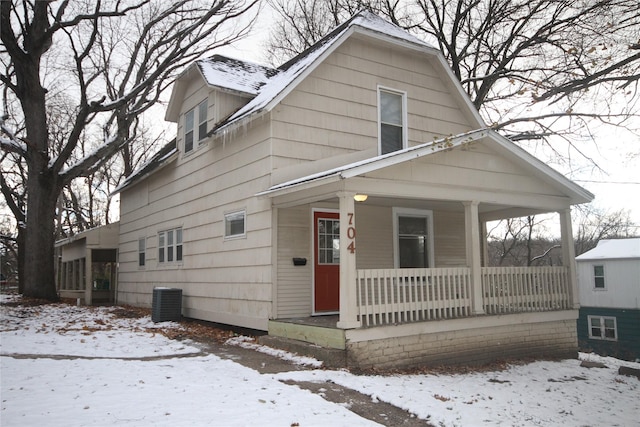 bungalow-style house with a porch and central air condition unit