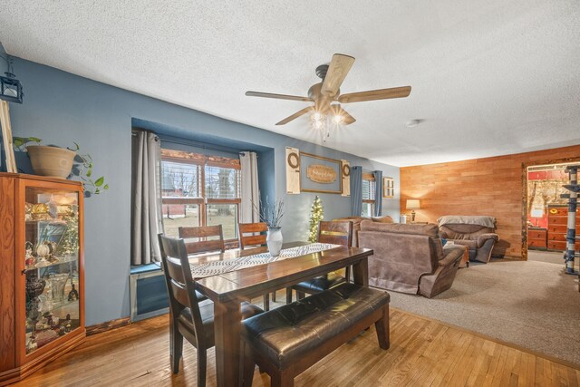 306 NW 2nd St, Melcher-Dallas, IA 50163 - dining area with wooden walls, a ceiling fan, wood finished floors, and a textured ceiling