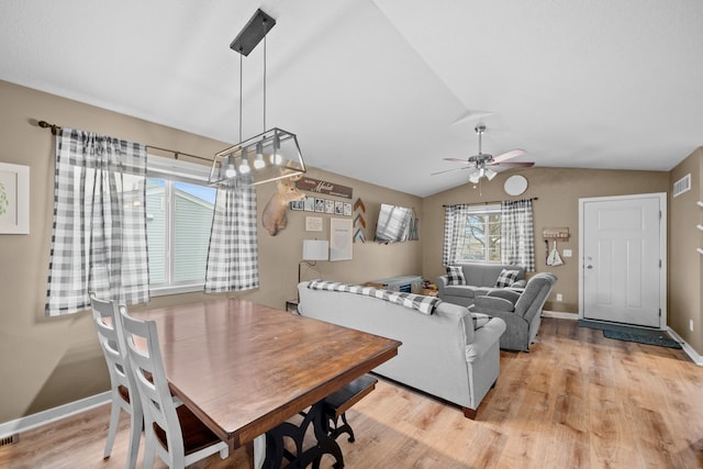 dining room featuring light hardwood / wood-style floors, a wealth of natural light, lofted ceiling, and ceiling fan