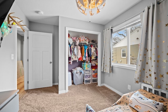 bedroom with a closet, an inviting chandelier, and light carpet