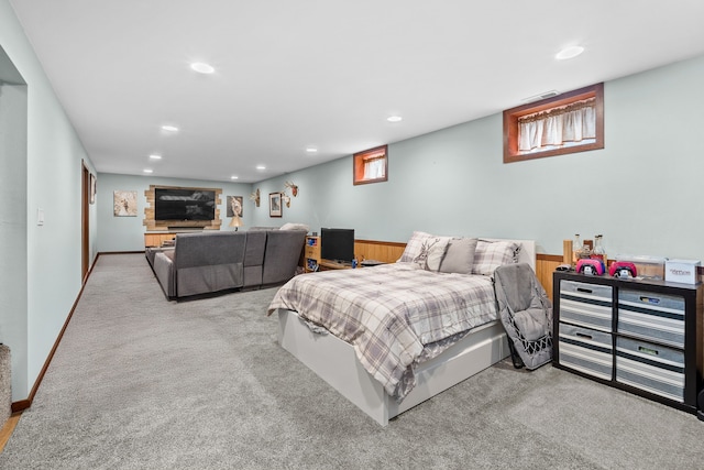 bedroom featuring wooden walls and light colored carpet