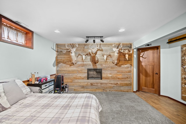 bedroom featuring hardwood / wood-style flooring and rail lighting