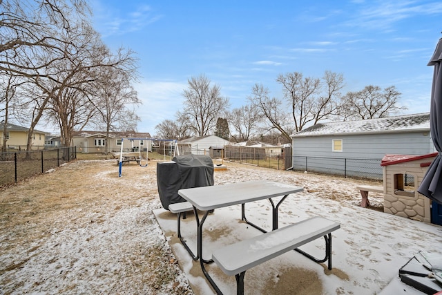 snow covered patio featuring a playground