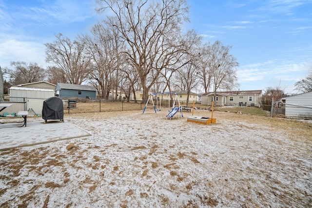 snowy yard featuring a playground