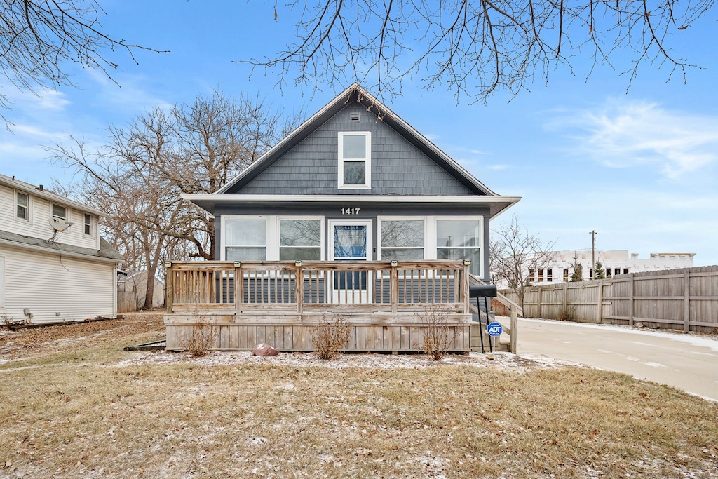 view of front of house featuring a deck and a front lawn