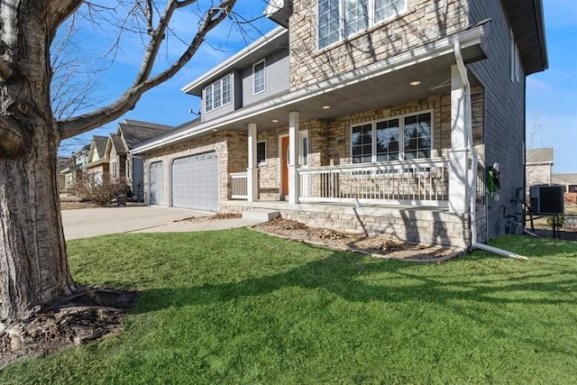 view of front of house with a garage, cooling unit, covered porch, and a front lawn