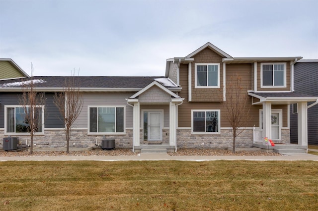 craftsman inspired home with a front lawn and central air condition unit