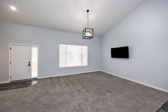 unfurnished living room featuring dark colored carpet and lofted ceiling