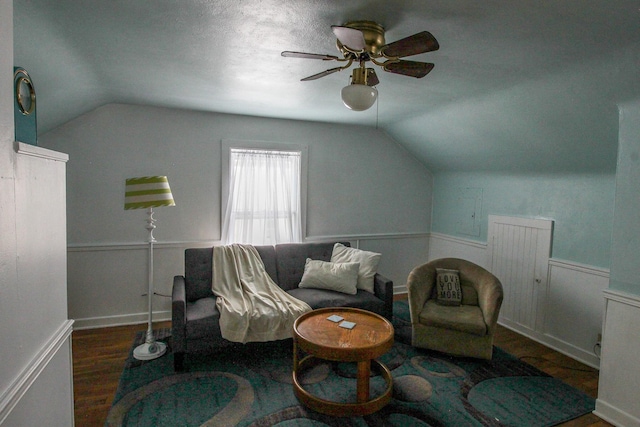 living area with ceiling fan, dark hardwood / wood-style flooring, and lofted ceiling