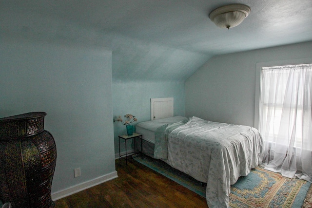 bedroom featuring dark hardwood / wood-style flooring and lofted ceiling