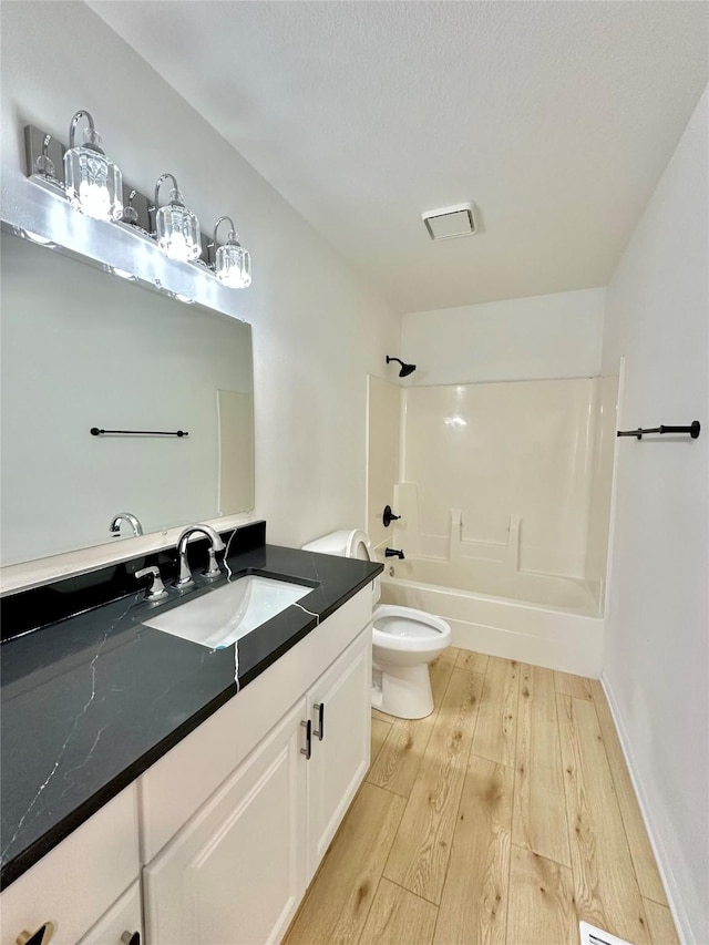 full bathroom featuring hardwood / wood-style flooring, shower / tub combination, toilet, and vanity