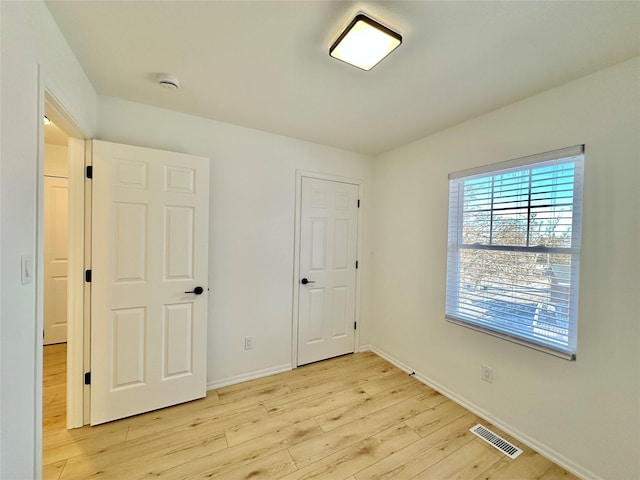 unfurnished bedroom with light wood-type flooring