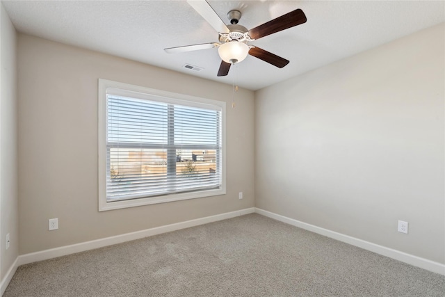 spare room featuring visible vents, baseboards, a ceiling fan, and carpet floors