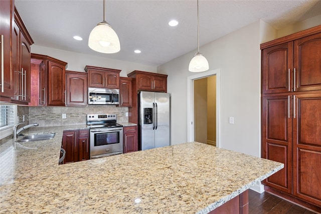 kitchen with a sink, tasteful backsplash, pendant lighting, and stainless steel appliances
