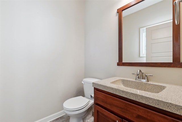bathroom with vanity, baseboards, and toilet
