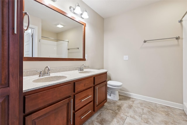 bathroom with walk in shower, baseboards, a sink, and double vanity