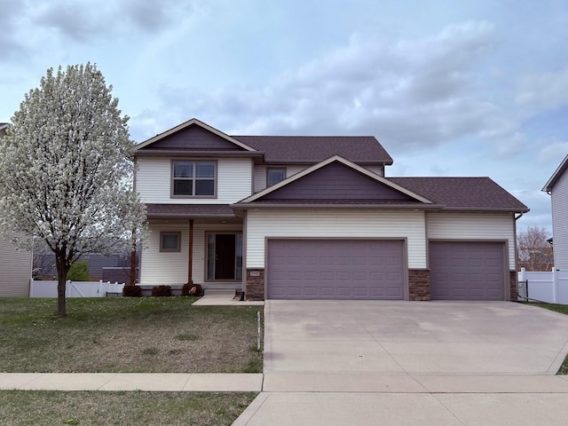craftsman inspired home with concrete driveway, a front lawn, stone siding, fence, and a garage