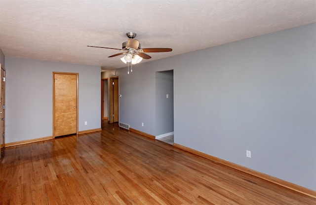 unfurnished room featuring light wood-type flooring, a textured ceiling, and ceiling fan