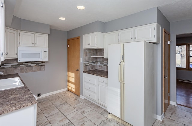 kitchen with sink, backsplash, white appliances, and white cabinets