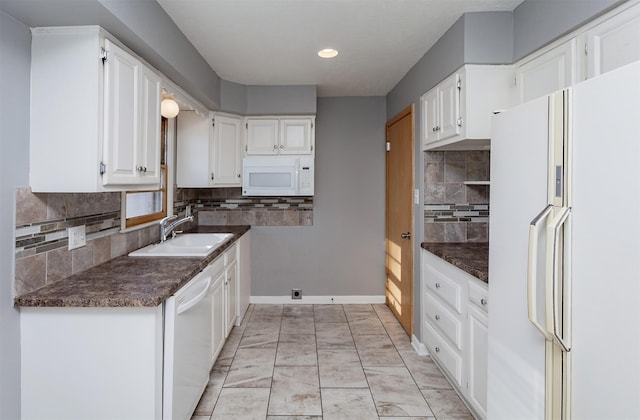 kitchen featuring sink, backsplash, white appliances, and white cabinets