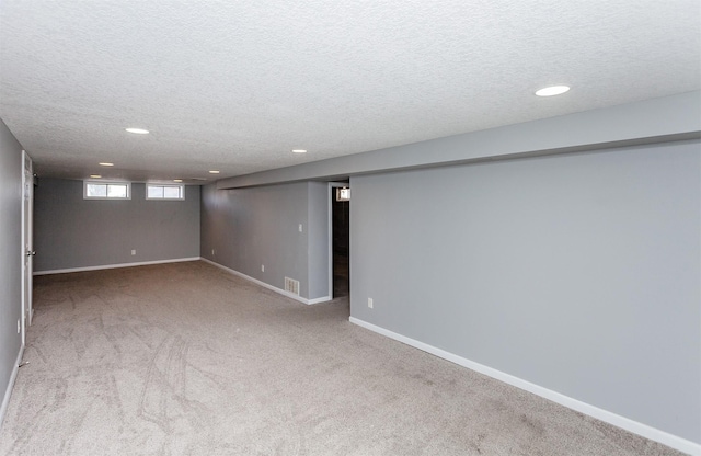 basement with carpet floors and a textured ceiling