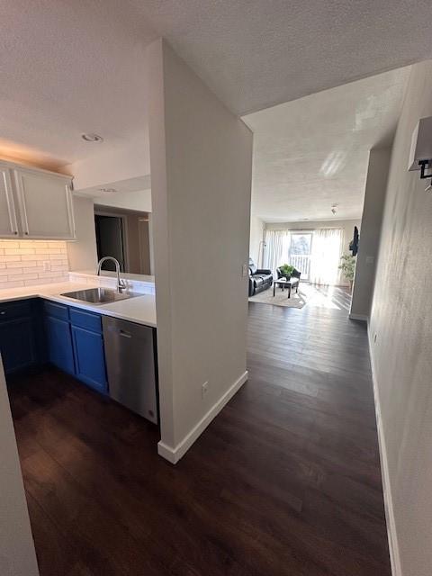 kitchen featuring blue cabinets, white cabinetry, sink, backsplash, and stainless steel dishwasher