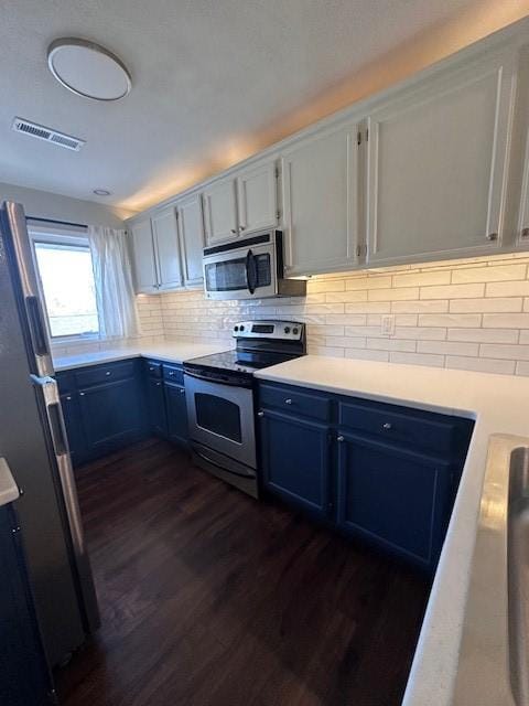 kitchen with white cabinetry, decorative backsplash, dark hardwood / wood-style floors, and appliances with stainless steel finishes