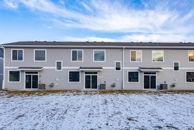 snow covered house featuring central air condition unit