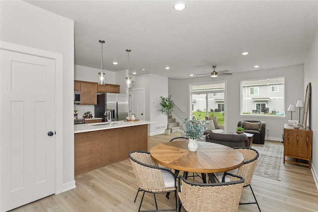 208 NW Waverly Dr, Waukee, IA 50263 - dining area featuring ceiling fan, stairs, light wood finished floors, recessed lighting, and baseboards