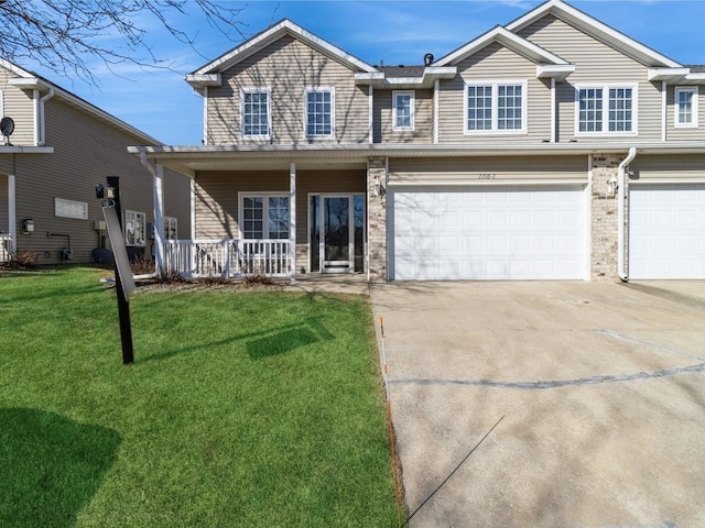 view of front of property featuring a porch, a garage, and a front lawn