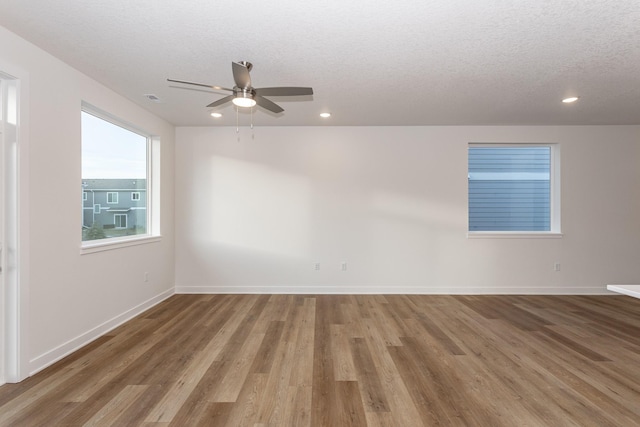 spare room with hardwood / wood-style floors, a textured ceiling, and ceiling fan