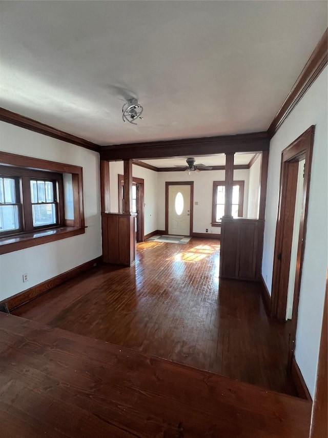 foyer with dark wood-type flooring, ceiling fan, ornamental molding, and ornate columns