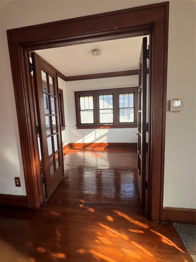 hallway featuring ornamental molding, dark wood-type flooring, and french doors