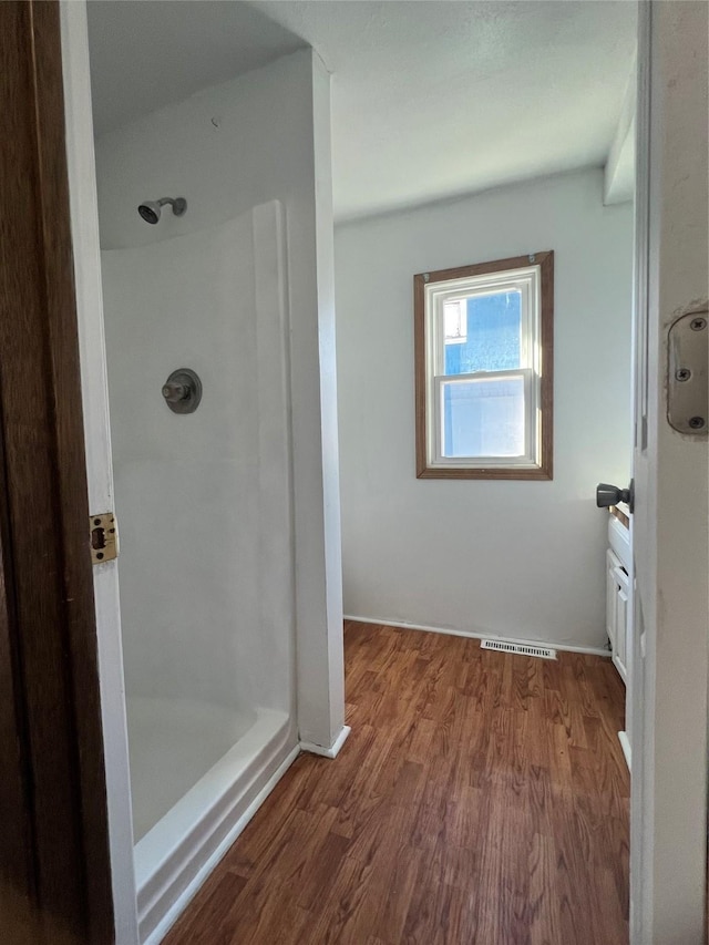 bathroom featuring hardwood / wood-style flooring and a shower