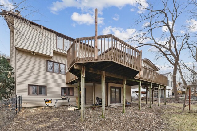back of property with a deck and fence