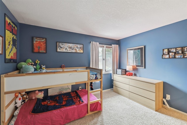 bedroom with carpet, baseboards, and a textured ceiling