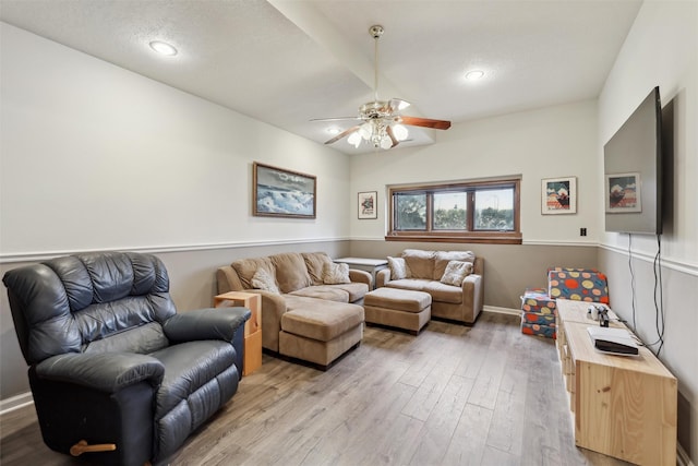 living room with a ceiling fan, baseboards, recessed lighting, light wood-style floors, and a textured ceiling