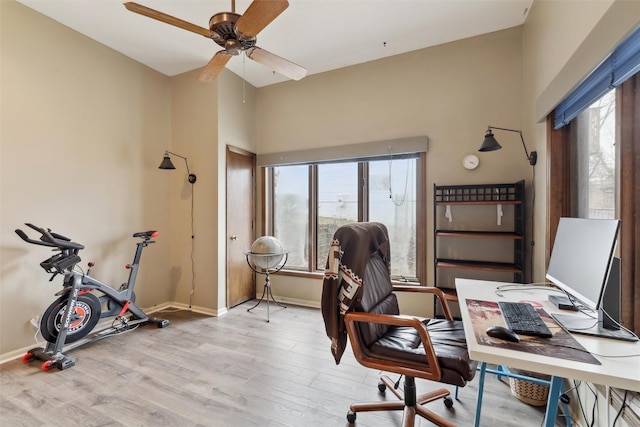 office space featuring baseboards, wood finished floors, and a ceiling fan