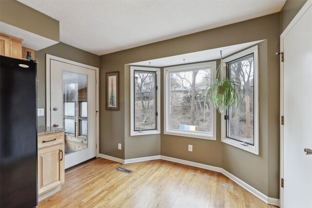 interior space with visible vents, baseboards, and light wood-style floors