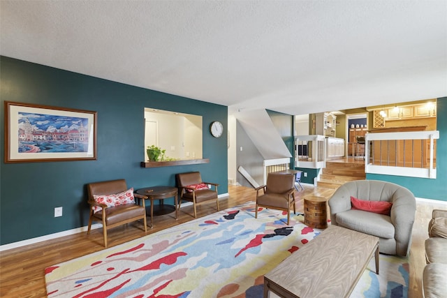 living room with wood finished floors, baseboards, and a textured ceiling