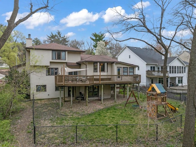 rear view of property featuring a wooden deck, a fenced backyard, a chimney, and a yard