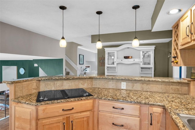 kitchen featuring black electric cooktop, hanging light fixtures, and light brown cabinets
