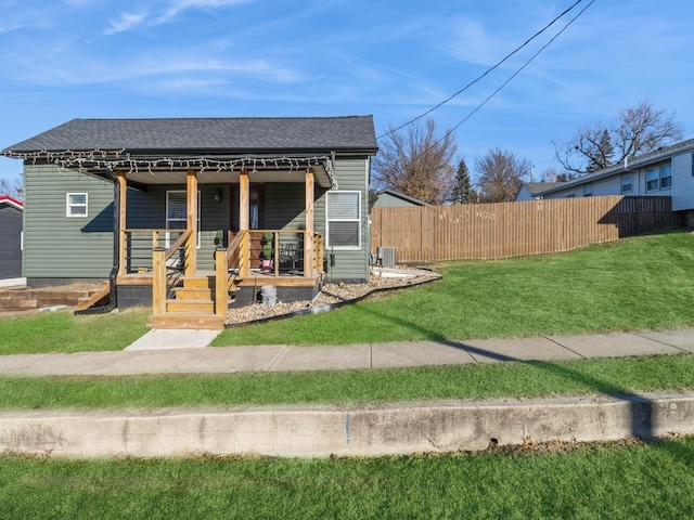 view of front facade with cooling unit, a front yard, and covered porch