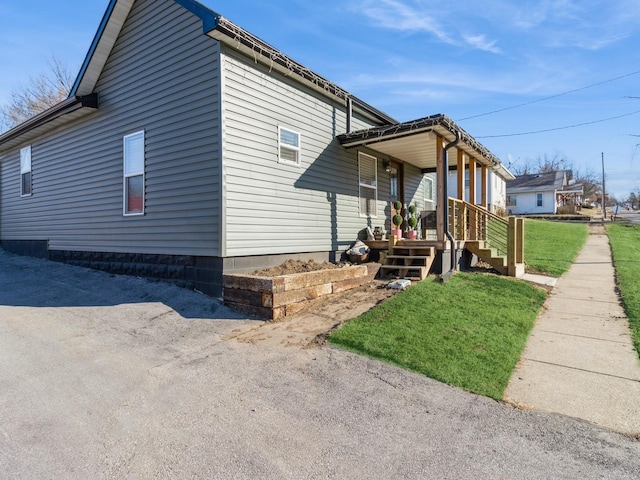 view of side of property with a porch and a yard